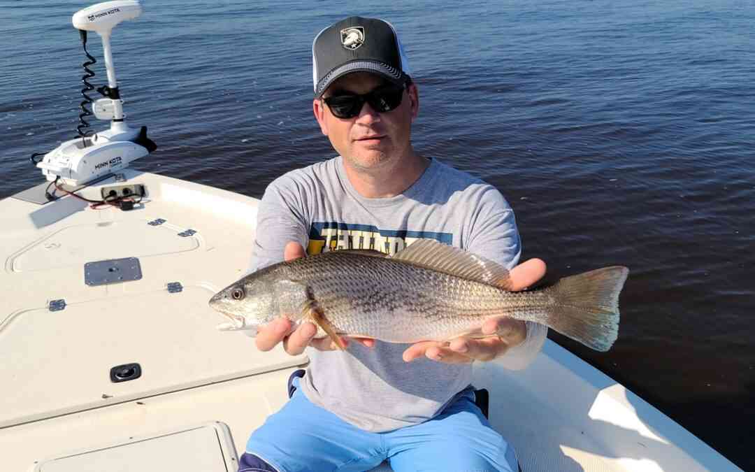 a fisherman with a redfish