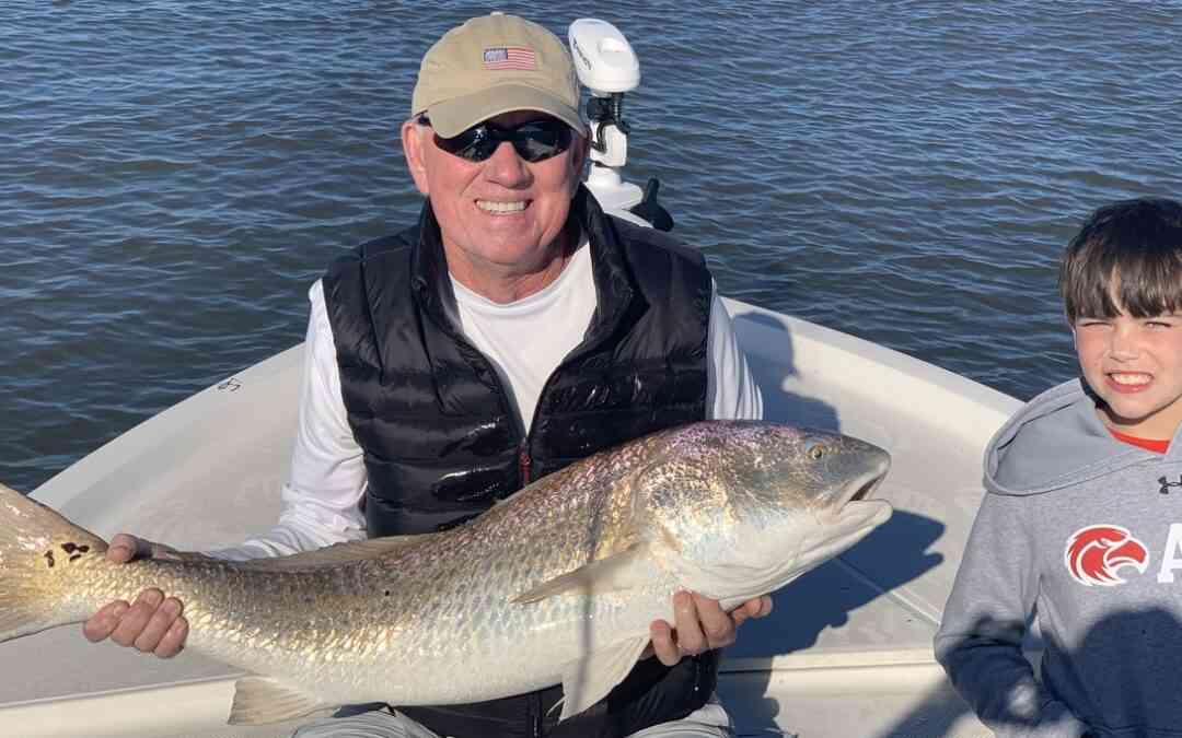 a fisherman with a redfish