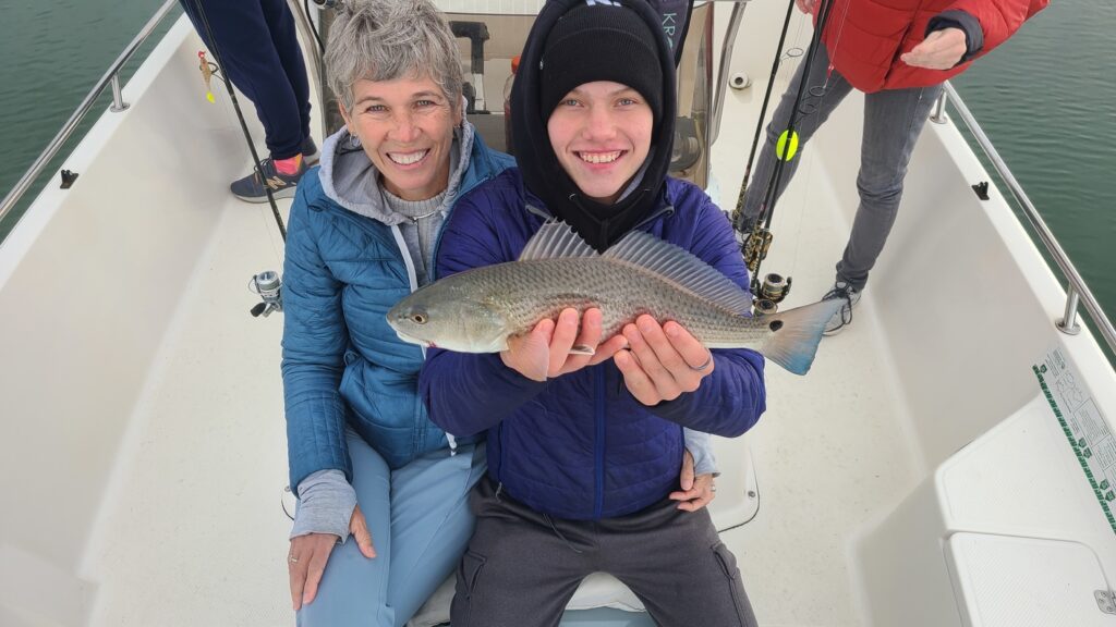 woman and son holding redfish 