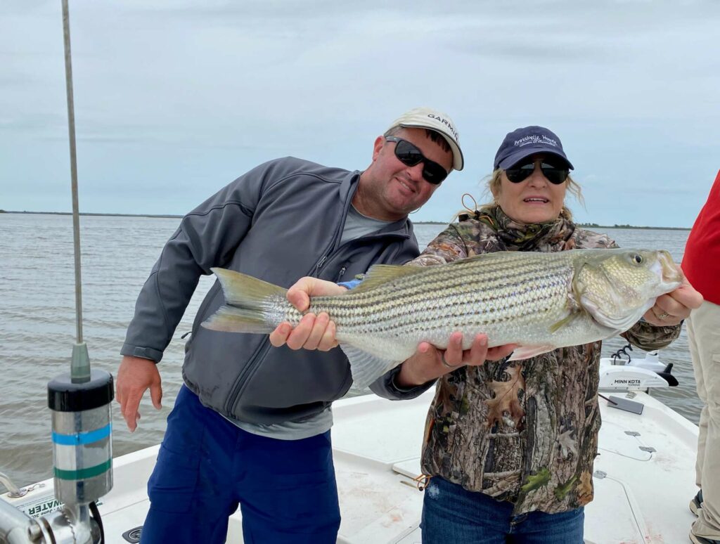 fishing guide and woman with striped bass