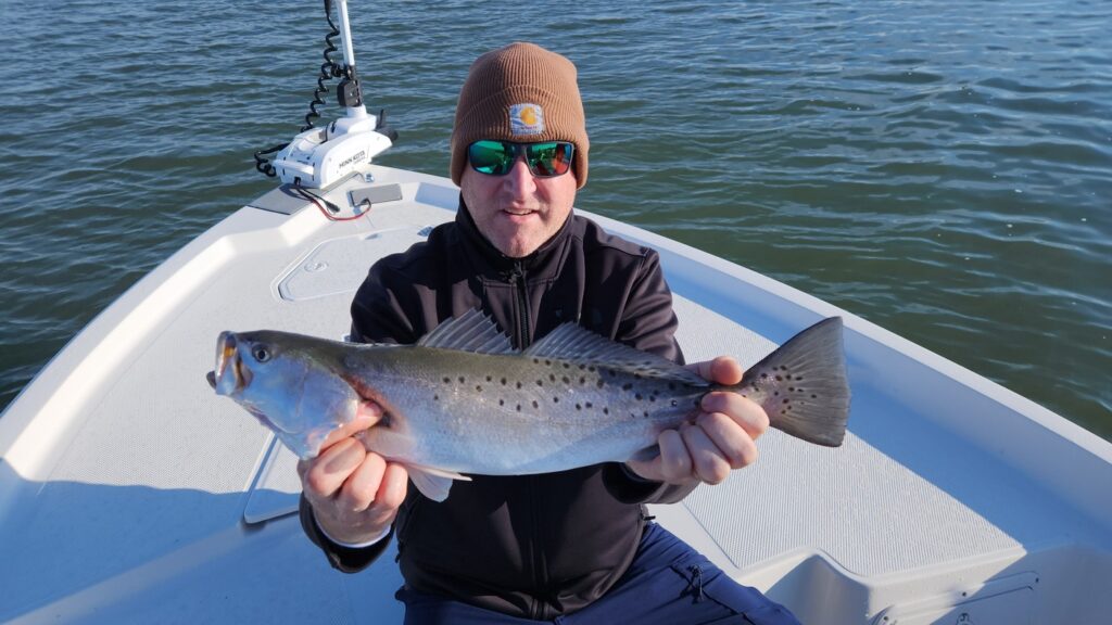 fisherman holding spotted sea trout near georgetown, south carolina