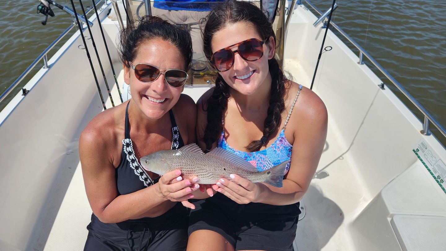mother and daughter holding fish
