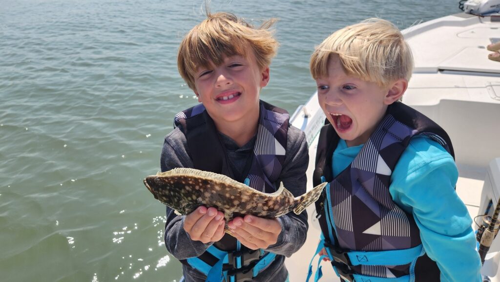 excited kids holding flounder