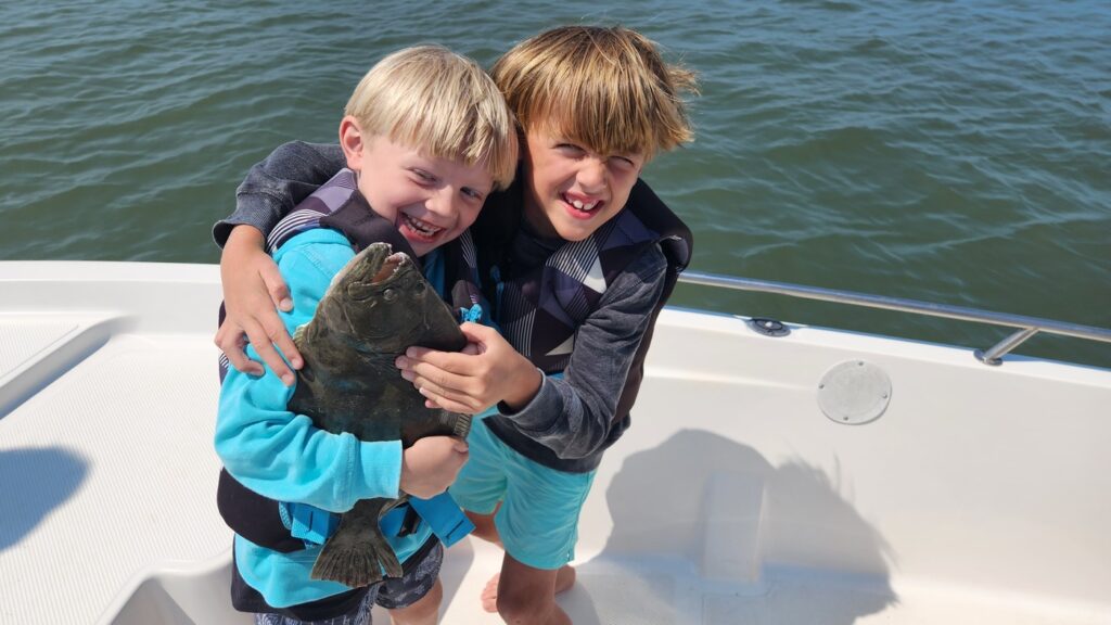 two boys holding big flounder