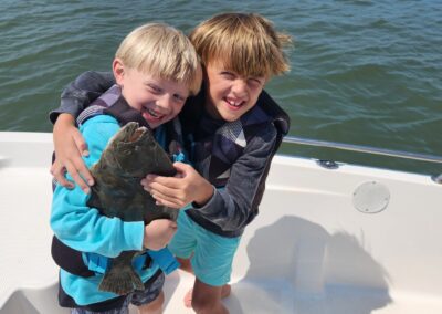 two boys holding big flounder