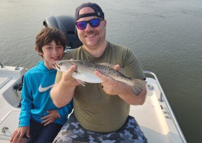man and boy holding speckled sea trout