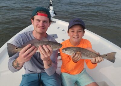 two boys with a pair of redfish