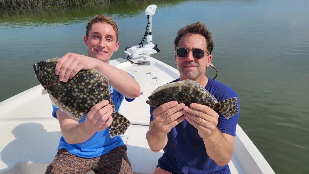 two fisherman holding two nice flounder