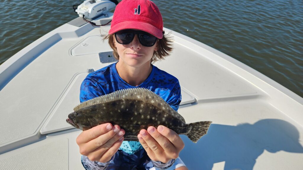 boy holding flounder near pawleys island