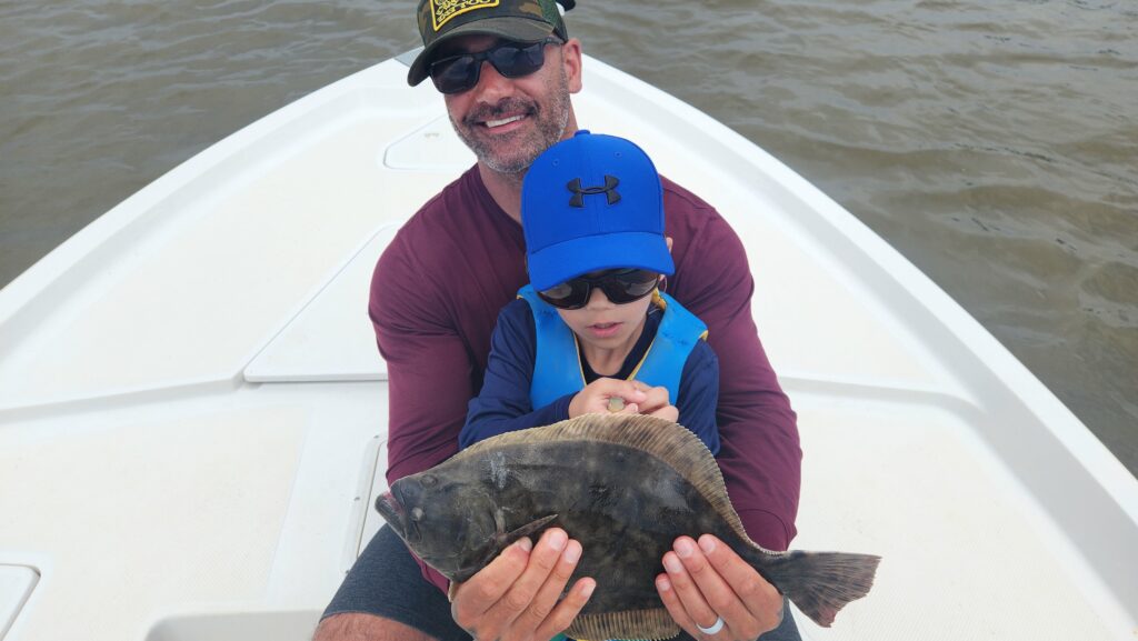 father and son holding a flounder in pawleys island, south carolina